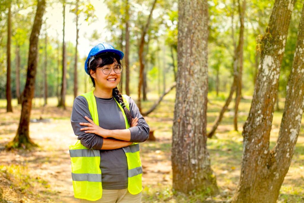 Beautiful and pretty engineer woman show action of confidence and smile with background of nature and forest in day light.