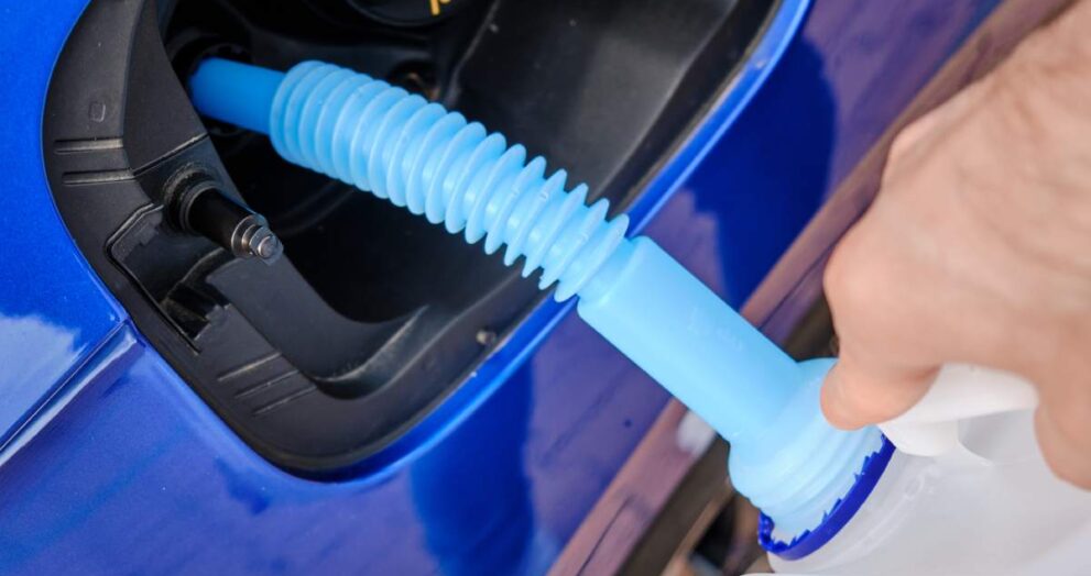 Close up filling of diesel exhaust fluid//adblue from canister into the tank of blue car for reduction of air pollution. Environmental or eco friendly solution.