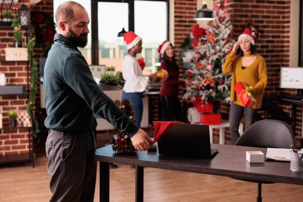 Depressed sad man getting fired on christmas eve, feeling unhappy and upset after being discharged from job. Losing work and being jobless on xmas day, career failure in festive workplace.