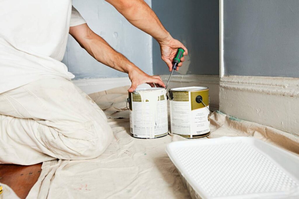 Person prepping for a painting project in a room under renovation