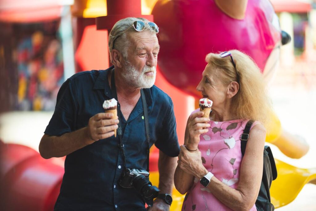 senior old couple celebration for Valentine's Day at Amusement theme park enjoying freedom relaxing, grandmother and grandfather smiling and fun, time to date and married