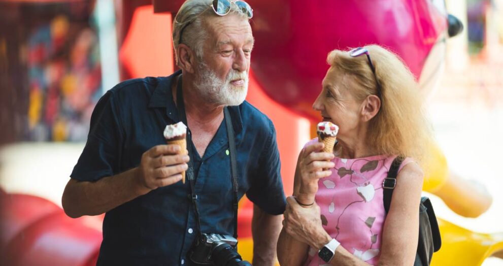 senior old couple celebration for Valentine's Day at Amusement theme park enjoying freedom relaxing, grandmother and grandfather smiling and fun, time to date and married