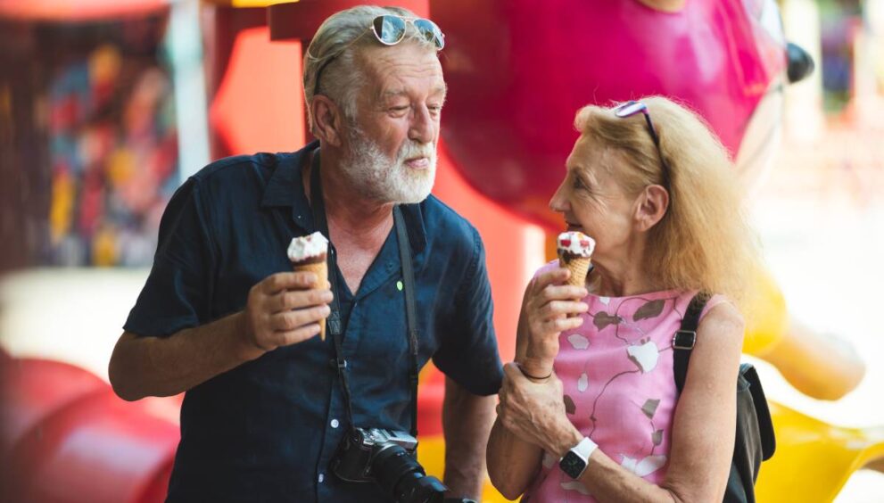 senior old couple celebration for Valentine's Day at Amusement theme park enjoying freedom relaxing, grandmother and grandfather smiling and fun, time to date and married