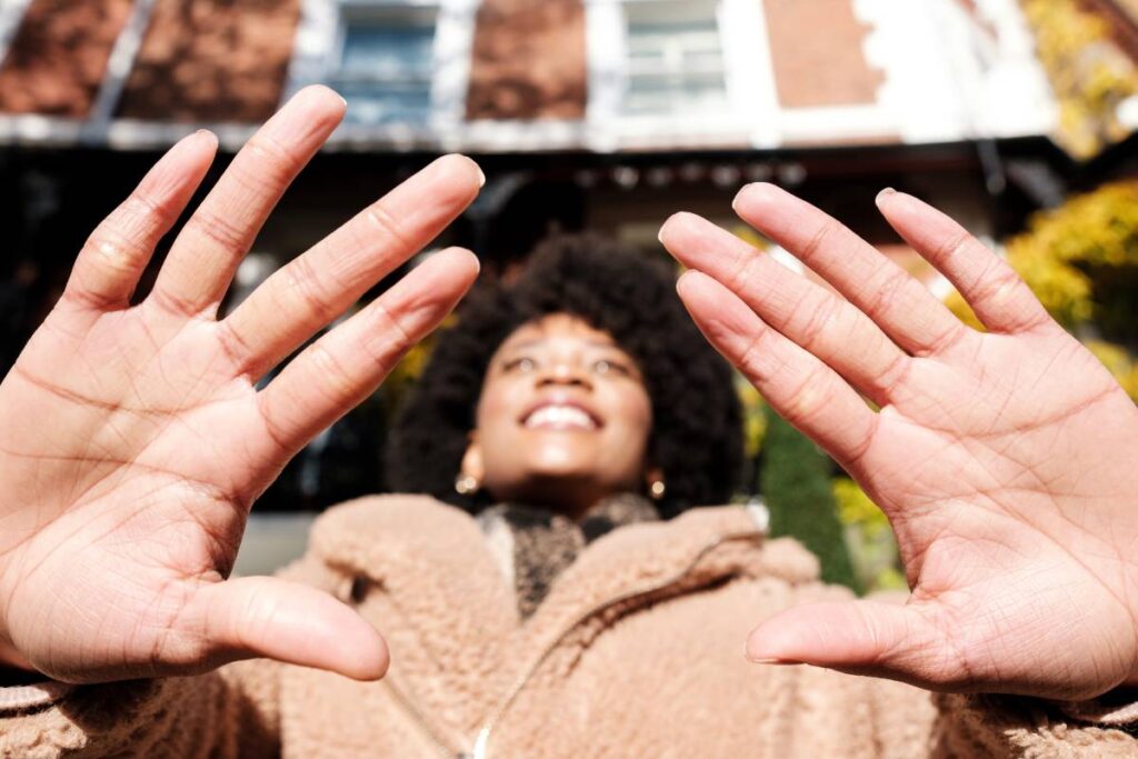 Close-up of palm of hands of young woman in the street.