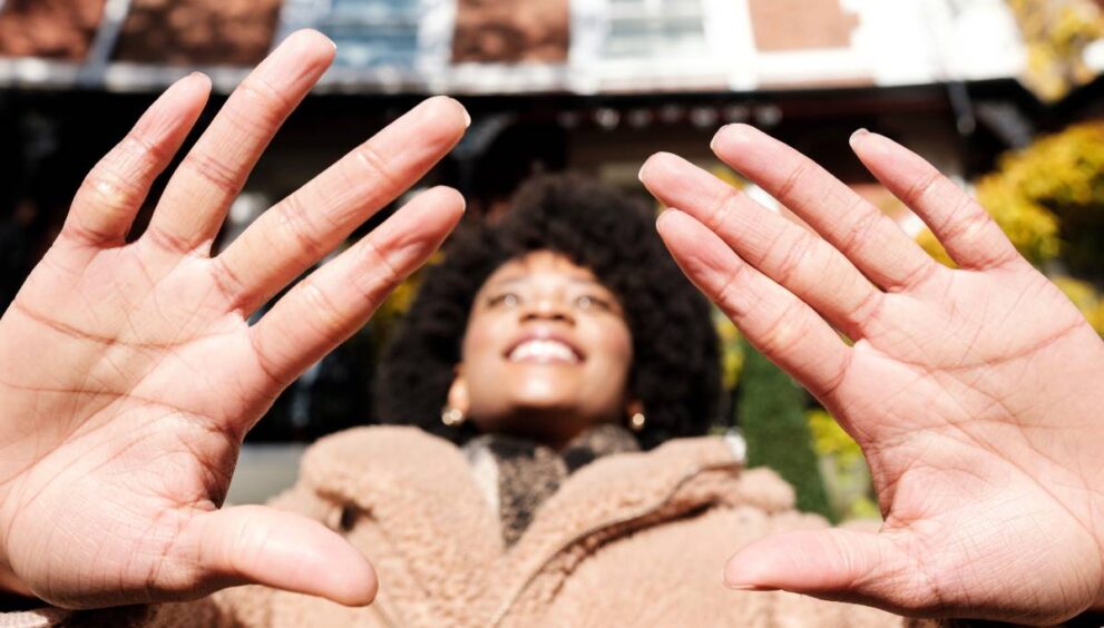 Close-up of palm of hands of young woman in the street.
