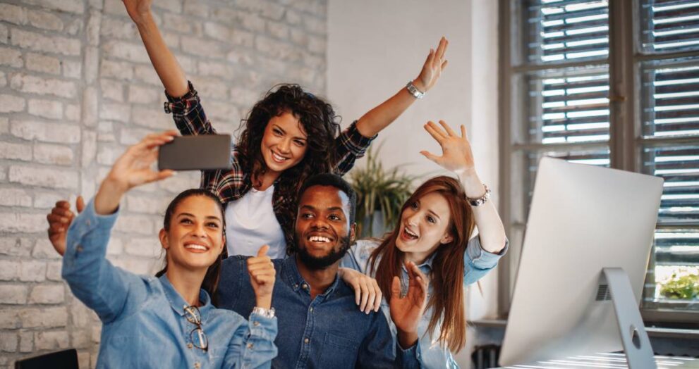 Group of young people doing selfie in the office